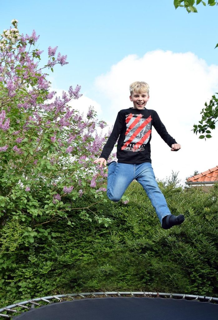 Kind springt enthousiast op trampoline en haalt alles uit de springervaring met veiligheid en plezier